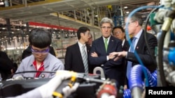 U.S. Secretary of State John Kerry (C) takes a tour of the Foton Cummins Engine plant in Beijing, Feb. 15, 2014. 