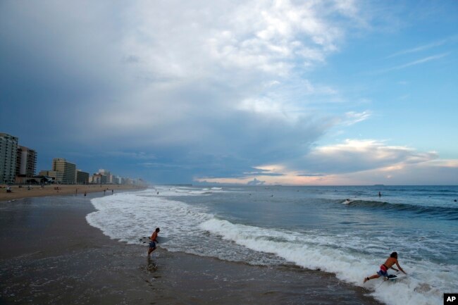 Surfers aprovechan las olas en Virginia Beach, Virginia, el 11 de septiembre de 2018, antes de la llegada del huracán Florence.
