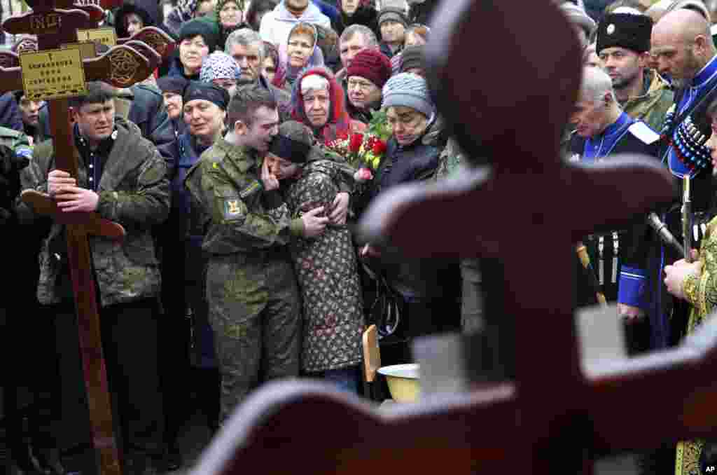 Family and friends of victims of the deadly attack on churchgoers in Russia's predominantly Muslim Dagestan region attend a funeral service in Kizlyar, Russia.