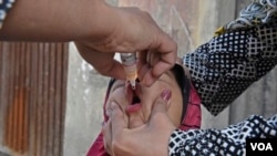 یک کودک هنگام دریافت واکسین ضد فلج کودکان در ولایت فراه (تصویر از آرشیف صدای امریکا)