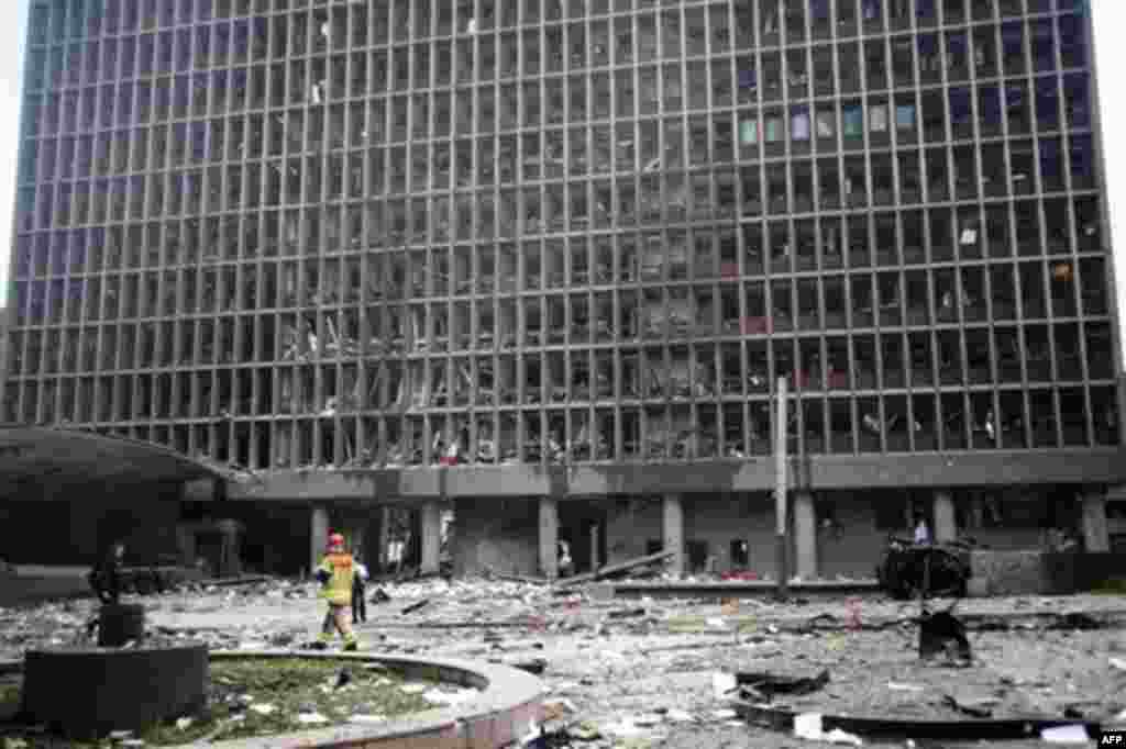 Debris covers the area outside a building in the centre of Oslo, Friday July 22, 2011, following an explosion that tore open several buildings including the prime minister's office, shattering windows and covering the street with documents. (AP Photo/Fart