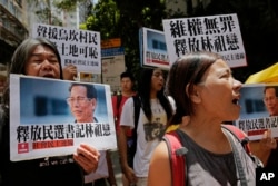 Protesters hold pictures of the Wukan village's 70-year-old leader, Lin Zuluan during a protest in Hong Kong, June 21, 2016.
