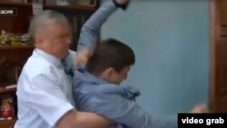 In an image taken from a video, Sergei Zaitsev, head of the Shirinsky region of Russia's Republic of Khakasia, appears to grab journalist Ivan Litoman, May 22, 2019.