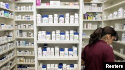 FILE - A pharmacy employee looks for medication as she works to fill a prescription while working at a drugstore in New York. IMS Health predicts global spending will increase by about 30 percent cumulatively from about $1 trillion now to about $1.3 trillion in 2020, driven by expensive new drugs, price hikes, aging populations and increased generic drug use in developing countries.