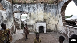 Des enfants jouent dans les ruines d'un camp de déplacés internes, à Kalemie, le 20 mars 2018.