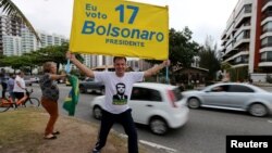 A supporter of presidential candidate Jair Bolsonaro is seen in front of Bolsonaro's condominium at Barra da Tijuca neighborhood in Rio de Janeiro, Brazil, Oct. 4, 2018.