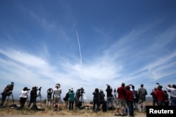People watch as the Ground-based Midcourse Defense (GMD) element of the U.S. ballistic missile defense system launches during a flight test from Vandenberg Air Force Base, Calif., May 30, 2017.