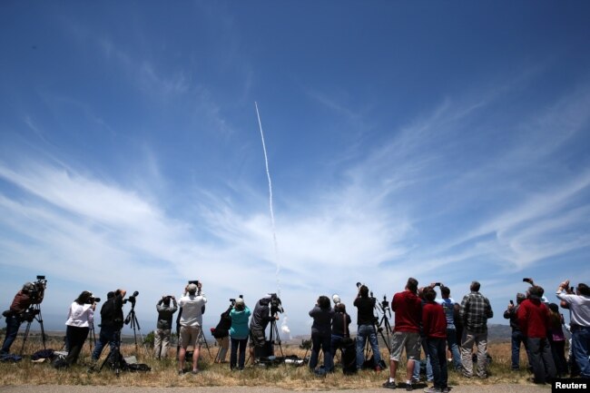 FILE - People watch as the Ground-based Midcourse Defense (GMD) element of the U.S. ballistic missile defense system launches during a flight test from Vandenberg Air Force Base, Calif., May 30, 2017.