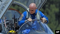 Mission Commander Mark Kelly climbs from his T-38 jet trainer as he arrives with the crew of space shuttle Endeavour's mission STS-134 at the Kennedy Space Center in Cape Canaveral, Florida, April 26, 2011
