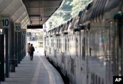 People walk along train platform during a general transport strike, in Milan, Italy, June 16, 2017.