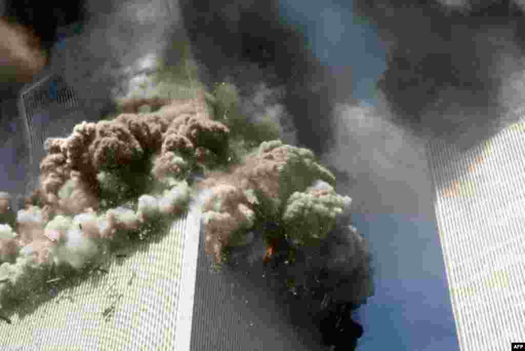 The south tower of the World Trade Center, left, begins to collapse after a terrorist attack on the landmark buildings in New York, Tuesday, Sept. 11, 2001. (AP Photo/Gulnara Samoilova)