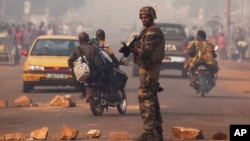 A French soldier waves through traffic as he mans a roadblock in the Miskine neighborhood of Bangui, Central African Republic, Jan. 6, 2014. 