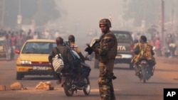 A French soldier waves through traffic as he mans a roadblock in the Miskine neighborhood of Bangui, Central African Republic, Jan. 6, 2014. 