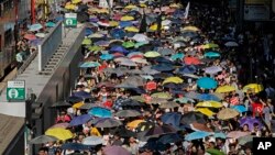 Thousands of protesters raise umbrellas during a rally to support young activists Joshua Wong, Nathan Law and Alex Chow in downtown Hong Kong, Aug. 20, 2017.