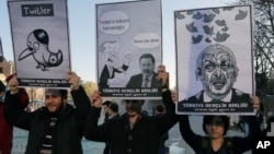 FILE - Members of the Turkish Youth Union hold cartoons depicting Turkey's PM Recep Tayyip Erdogan during a protest against a ban on Twitter, Ankara, March 21, 2014.