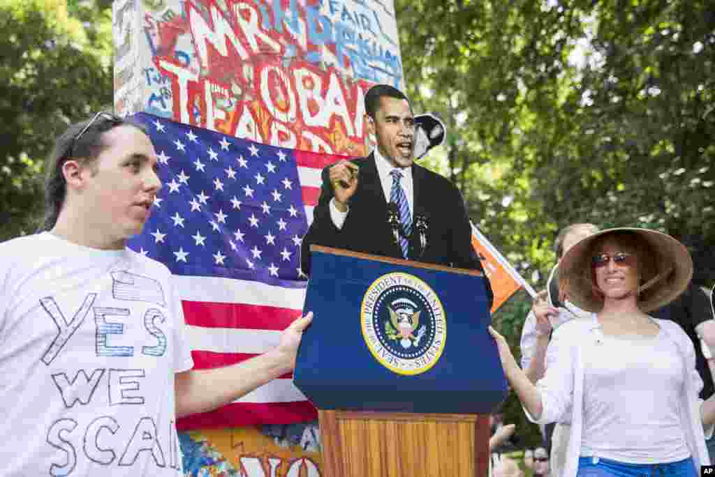 Protesters display a cut out figure of U.S. President Barack Obama in front of a replicate piece of the former Berlin Wall reading &quot;Mr Obama tear down Wall Street&quot; in Berlin, June 19, 2013. 