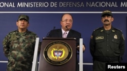 Colombia's Defense Minister Luis Carlos Villegas (C) delivers a speech, next to Colombian armed forces chief General Juan Pablo Rodriguez (L) and director of national police General Rodolfo Palomino (R) during a news conference in Bogota, Colombia October
