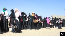 FILE - Ethiopian women wait in a line at custom area as they arrive at Bole International Airport in Ethiopia’s capital, Addis Ababa, Dec. 18, 2013, after they were deported from Saudi Arabia. 