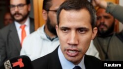 FILE - Venezuelan opposition leader and self-proclaimed interim president Juan Guaido talks to the media before a session of the Venezuela’s National Assembly in Caracas, Jan. 29, 2019. 