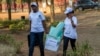 Polling staff carry a ballot box before counting at a polling center in Kigali, Rwanda, Aug. 4, 2017.