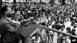 Reveran Martin Luther King Jr. ki t ap pran lapawòl devan yon foul anviwon 3 mil moun, nan dat 6 avril 1966, nan Kelly Ingram Park, vil Birmingham, sou 3èm jou yon toune 3 jou atravè Eta Alabama.