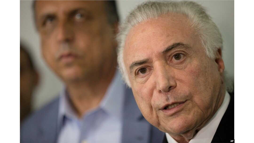 Brazil's President Michel Temer, right, talks to the press next to the Governor of Rio de Janeiro Luiz Fernando Pezao after a meeting with local authorities about the implementation of a decree that has placed the military in charge of Rio's state security at the Guanabara Palace in Rio de Janeiro, Feb. 17, 2018.