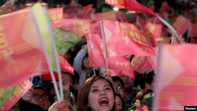 在台北民进党总部外的蔡英文总统的支持者举旗欢呼。（2020年1月11日）