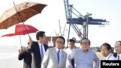 Wakil Perdana Menteri merangkap Menteri Keuangan Jepang, Taro Aso (tengah) didampingi Ketua Asosiasi Jepang-Burma, Hideo Watanabe (tengah, kanan( mengunjungi sebuah kawasan industri di Thilawa, dekat Yangon (Rangun), 4 Januari 2013. (REUTERS/Pool)