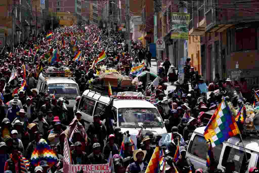 Anti-government demonstrators accompany the coffins that contain the remains of people killed in clashes between supporters of former President Evo Morales and security forces, in a funeral procession into La Paz, Bolivia.