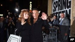 FILE - Bruce Springsteen and his wife, Patti Scialfa, exit out the stage door after the "Springsteen on Broadway" opening night performance at the Walter Kerr Theatre in New York, Oct. 12, 2017. 