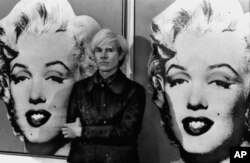 America's pop art painter and filmmaker, Andy Warhol, stands in front of his double portrait of the late Hollywood film star, Marilyn Monroe, at The Tate Gallery in London, February 15, 1971, at a press preview of his exhibition. (AP Photo)