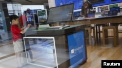 一名儿童站在纽约一家微软商店的展示有着视窗10操作系统的电脑展示台前。（2015年7月29日）