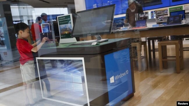 微软正在引领职场文化，将允许更多员工永久在家办公。图为一名儿童站在纽约一家微软商店的电脑视窗10操作系统的展示台前。（路透社2015年7月29日资料照）