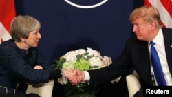 도널드 트럼프 미국 대통령이 25일 세계경제포럼이 열리고 있는 스위스 다보스에서 테레사
메이 영국 총리와 만나 악수하고 있다.