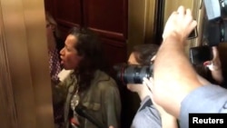 A protester confronts Senator Jeff Flake in an elevator in Washington, D.C., Sept. 28, 2018 in this still image obtained from a social media video.