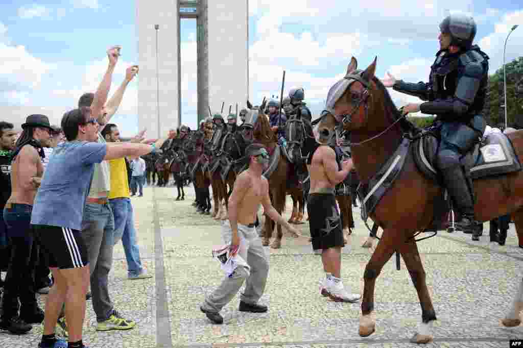 Demonstrators gather next to Planalto Palace to protest against the government in Brasilia. Brazil&#39;s former president Luiz Inacio Lula da Silva was sworn as chief of staff to his embattled successor Dilma Rousseff amid angry protests from opponents who accuse him of trying to dodge corruption charges.