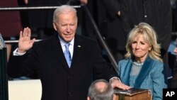 Joe Biden diambil sumpahnya sebagai presiden AS ke-46 oleh Hakim Agung John Roberts sementara Jill Biden memegang Alkitab.