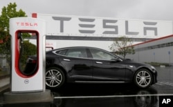 FILE - A Tesla car is parked at a charging station outside a Tesla factory in Fremont, California, May 14, 2015. Many enviromentalists in the U.S. have embraced the arrival of electric cars but to date they have captured only one percent of the U.S. automobile market and still depend on government subsidies.