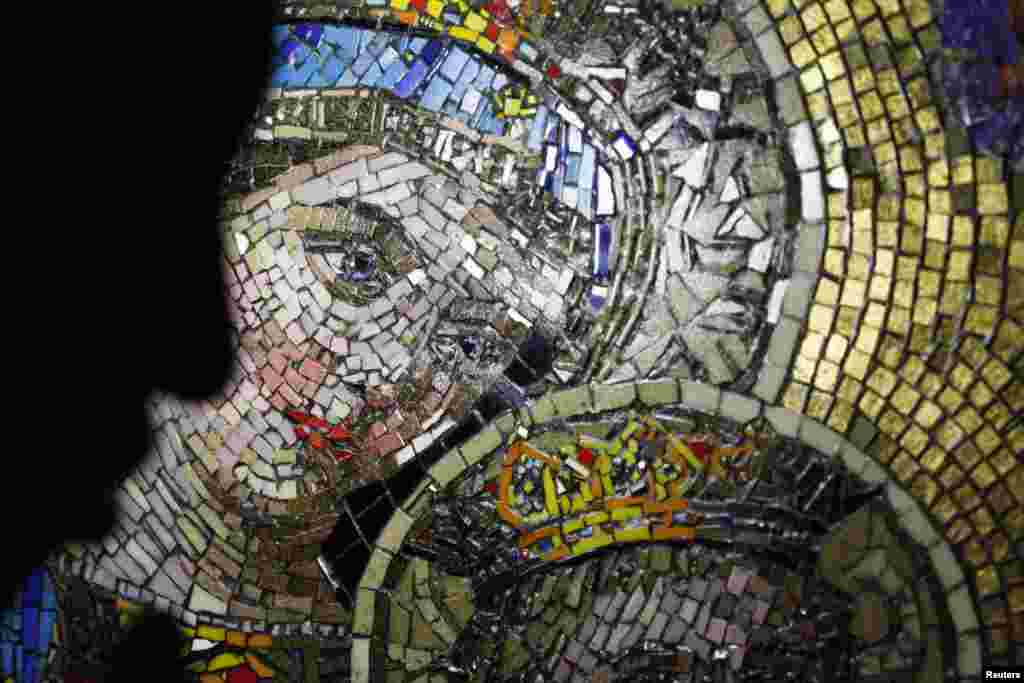 Seorang pengunjung melewati gambar Perawan Maria, pada saat ribuan orang Mesir Koptik merayakan Perayaan Assumption di Gereja Perawan Maria di Mostorod, Cairo timur.&nbsp; Perayaan itu menandai kenaikan Perawan Maria ke surga. &nbsp;