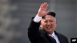ຜູ້ນຳເກົາຫຼີເໜືອ Kim Jong Un ໂບກມື ໃນລະຫວ່າງ ການເດີນສວນສະໜາມ ດ້ານທະຫານ ໃນນະຄອນຫຼວງ Pyongyang ຂອງເກົາຫຼີເໜືອ ເພື່ອສະເຫຼີມສະຫຼອງ ວັນຄົບຮອບ 105 ປີ ຂອງມື້ລາງ Kim Il Sung ຜູ້ກໍ່ຕັ້ງປະເທດ ແລະ ຫຼານຊາຍຜູ້ປົກຄອງປະເທດໃນປັດຈຸບັນ, ວັນທີ 15 ເມສາ 2017.