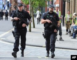 Policías armados patrullan las calles cercanas al Manchester Arena.