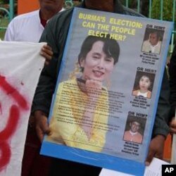 Protester holds opposition leader Aung San Suu Kyi's poster outside a public park in Mae Sot, Thailand, 07 Nov 2010