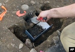 Emma Wink, part of an archaeological team, digs at the site of a 1600's Native American fort in Norwalk, Conn., Aug. 28, 2018.