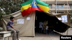 A boy sits outside a polling station, as Ethiopia's national election kicks off in capital Addis Ababa, May 24, 2015. 