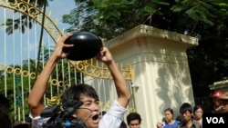 ນັກສຶກສາ ທີ່ປະທ້ວງຄົນນຶ່ງ ຍໍບາດຂອງຄູບາ ໃນທ່າຂວ້ຳລົງ ຊຶ່ງເປັນສັນຍາລັກ ຂອງການຕໍ່ຕ້ານລັດຖະບານ ຢູ່ໃນມຽນມາ (15 ພະຈິກ 2014)

