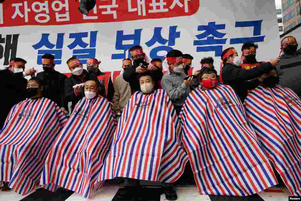 Pemilik usaha kecil Korea Selatan mencukur habis rambut mereka selama protes terhadap aturan jarak sosial baru pemerintah yang mulai berlaku awal bulan ini di dekat Majelis Nasional di Seoul, Korea Selatan (25/1). (Foto: Reuters)
