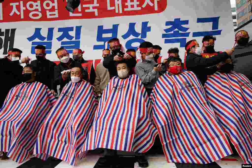 Business owners have their heads shaved during a protest near the National Assembly in Seoul, against the government's new social-distancing rules that went into effect earlier this month.