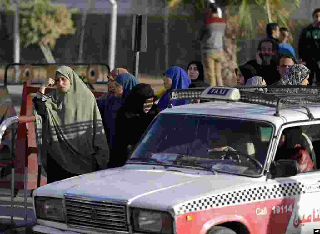 Para anggota keluarga pasukan keamanan yang tewas di Sinai menunggu jenazah kerabat mereka di pangkalan udara militer Almaza di Kairo (30/1). ​(AP/Hassan Ammar)