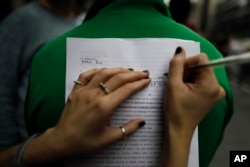 A woman fills out a form to renounce her religious affiliation in Buenos Aires, Argentina, Aug. 18, 2018. People renounced their religion nationwide after a bill to legalize elective abortions in the first 14 months of pregnancy was rejected by senators in recent weeks.