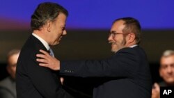 En esta foto de archivo se ve al presidente de Colombia Juan Manuel Santos, (izquierda) saludando a Rodrigo Londoño, alias Timochenko, máximo líder de las FARC, tras firmar el acuerdo de paz en Bogotá, Colombia.